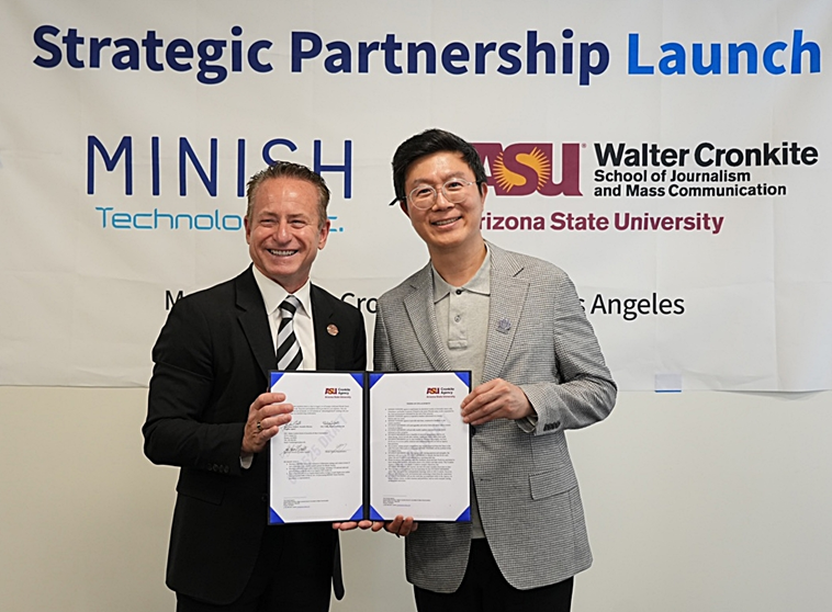 MINISH Technologyとアリゾナ州立大学のロゴが入った「Strategic Partnership Launch」と書かれた垂れ幕の前で、2人の男性がパートナーシップ契約書を掲げている。